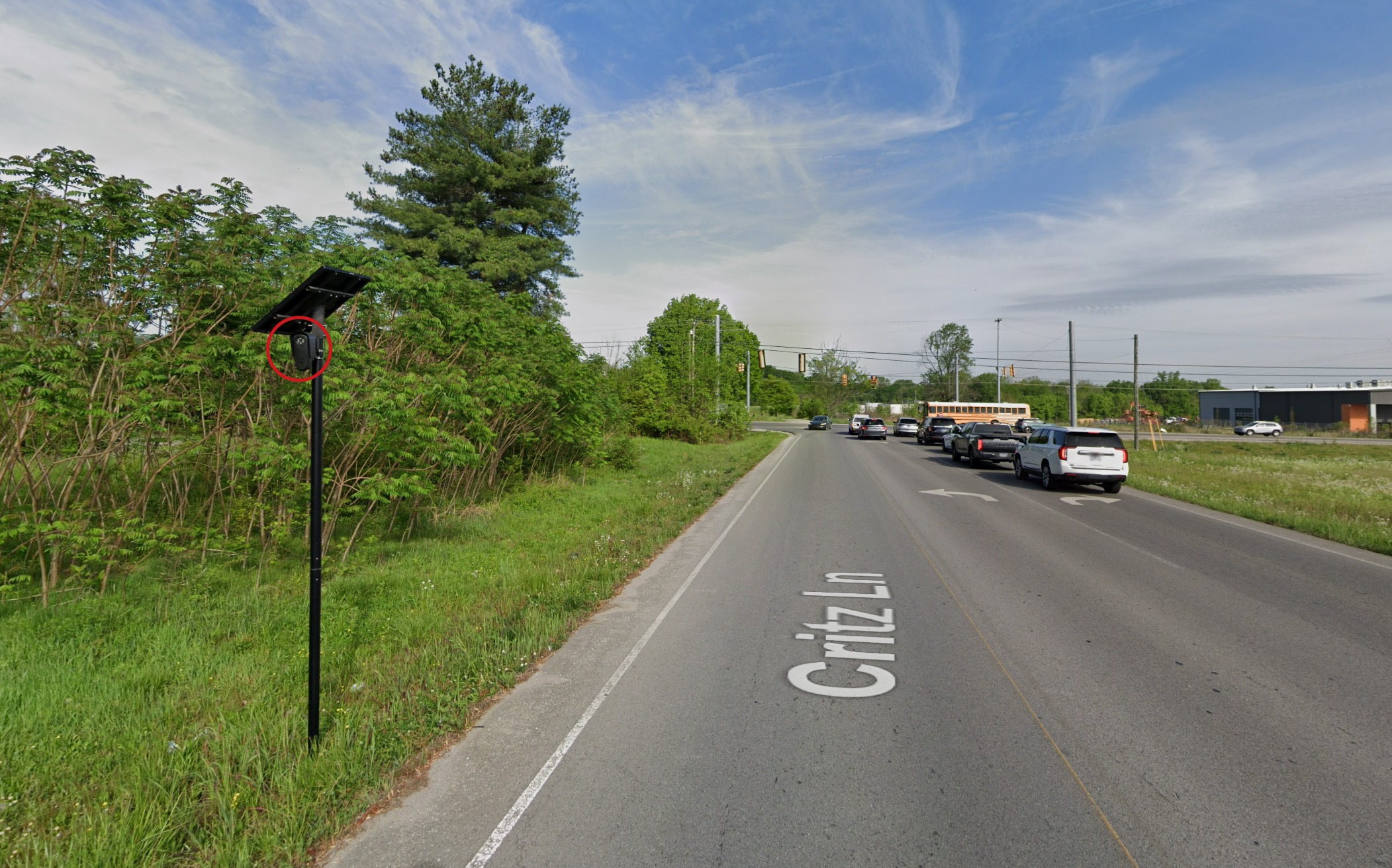 Critz Lane, a residential road with everyday traffic, and a pole-mounted camera circled in red along the shoulder.