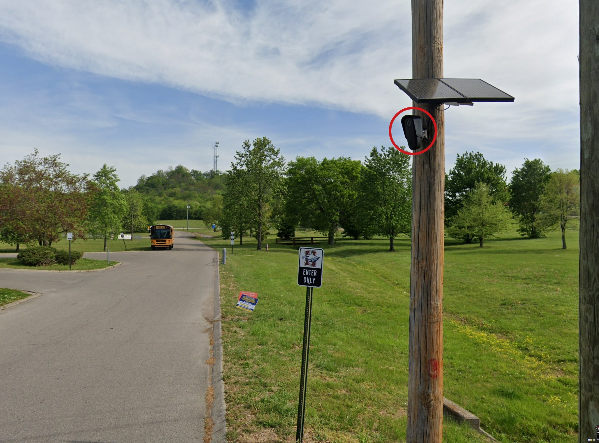 Heritage Elementary School entrance road, with a school bus, an Enter Only sign, and a pole-mounted camera circled in red.